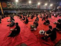 Iranians wearing face masks against the Covid-19 coronavirus attend Laylat al-Qadr prayers, one of the holiest nights during the Muslim fasting month of Ramadan, outside a mosque in the Tehran, on May 13, 2020. ATTA KENARE / AFP