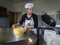 Sylwia Szlandrowicz prepares cheese on "Frontiera Ranch" in the Masuria - polish lake region, May 15, 2020. The sheep and cows are in the meadow, the cheese is ripening in a room on the ground floor -- just the kind of scene attracting increasing numbers of Polish cityslickers away from the urban jungle. Wojtek RADWANSKI / AFP