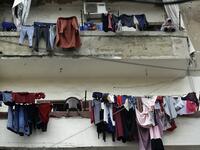 A woman stands next to laundry lines hanging out to dry on a balcony in the Bab al-Tabbaneh neighbourhood of Lebanon's northern city of Tripoli on June 3, 2020. Thousands of residents of Lebanon's northern Tripoli struggle to put food on the table, as the country's worst economic crisis in decades has picked up in speed in recent weeks, with food prices rising by more than 70 percent since the autumn. Inflation has been a blow in the country where more than 45 percent of the country's population now lives b