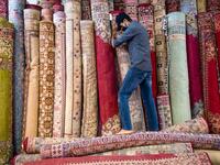A Moroccan rug dealer lines up carpets at a shop in the city of Sale, north of the capital Rabat, on June 3, 2020, during the novel coronavirus pandemic. Artisans in Morocco have been starved of income for almost three months because of the COVID-19 pandemic. The crafts industry represents some seven percent of GDP, with an export turnover last year of nearly 1 billion dirhams ($100 million). FADEL SENNA / AFP