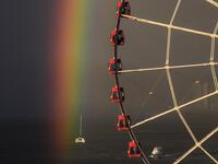 Passengers (top C) sit in a ferris wheel as a rainbow appears during sunset after a rain shower in Hong Kong on June 16, 2020. Anthony WALLACE / AFP