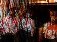 This picture taken on June 15, 2020 shows fake blood on the window of a car as actors (L-R) Kota Hanegawa, 28, Kenta Iwana, 25, and Asami Takeuchi, 33, rest after a demonstration of a drive-in haunted house at a garage in Tokyo. Philip FONG / AFP