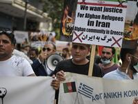 Afghans living in Athens carry a placard, demanding rights for Afghan refugees in Iran, as they participate with others in a rally in Athens on June 20, 2020, marking World Refugee Day, demanding rights and housing for refugees and migrants in Greece. Louisa GOULIAMAKI / AFP