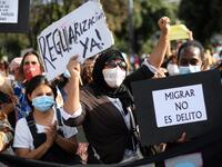 Women hold placrds rading !Legalization now" and "To migrate is not a crime" during a migrant´s demonstration in Barcelona on June 20, 2020, marking World Refugee Day and demanding legal papers for refugees and migrants in Spain. Josep LAGO / AFP