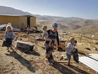 An Israeli settler woman walks with children in the Maoz Ester outpost located next to the Israeli settlement of Kokhav HaShahar in the occupied West Bank on June 18, 2020. The government of Israeli Prime Minister Benjamin Netanyahu has said it could begin the process to annex Jewish settlements in the West Bank as well as the strategic Jordan Valley from July 1. The plan -- endorsed by Washington -- would see the creation of a Palestinian state, but on reduced territory, and without Palestinians' core dema