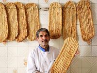 Iranian baker Esmail Asghari, 66, poses with Barbari bread in Tehran on June 7, 2020. ATTA KENARE / AFP