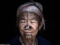 Striking images reveal the distinctive facial features of the Konyak tribe from North Eastern India, thought to be over 80 years old. A woman sporting two nose plugs and black markings across her face gazes wistfully out of the shot. (Mediadrumimages/ Trevor Cole)