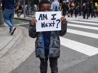 A boy holds a sign during a protest Friday in downtown Los Angeles over the death of George Floyd (unicefus/Instagram)