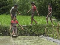 In this photograph taken on June 29, 2020 a mud-covered girls play in a rice paddy field during "National Paddy Day", which marks the start of the annual rice planting season, in Tokha village on the outskirts of Kathmandu. PRAKASH MATHEMA / AFP