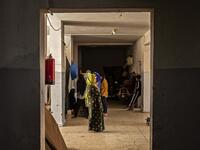 People stand in a hallway at a school building where Syrians -- displaced from the area of Ras al-Ain by the Turkish offensive on the northeast -- are staying in the city of Hasakah, on June 30, 2020. Delil SOULEIMAN / AFP