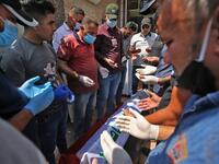 Mourners pray over the coffin of slain Iraqi jihadism expert Hisham al-Hashemi, who was shot dead yesterday outside his house in the Iraqi capital, during his funeral in Baghdad’s Zayouna district on July 7, 2020. Hashemi was an authoritative voice on Sunni jihadist factions including the Islamic State group, but was also frequently consulted by media and foreign governments on domestic Iraqi politics and Shiite armed groups. He had warm ties with top decision-makers, including President Barham Saleh.