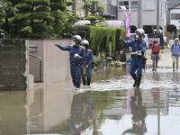 Fire brigade officers check on residents following heavy rain in Omuta, Fukuoka Prefecture on July 8, 2020. Torrential rain pounded central Japan on July 8 as authorities said 58 people were feared dead in days of heavy downpours that have triggered devastating landslides and terrifying floods. STR / JIJI PRESS / AFP