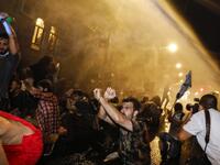 Israeli police spray protesters (clad in masks due to the COVID-19 coronavirus pandemic) with water cannon during an anti-government demonstration in Jerusalem, on July 18, 2020. Ahmad GHARABLI / AFP