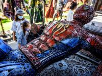 This photograph taken on July 18, 2020 shows tourists looking at a life-sized Spiderman sculpture made of scrap metal parts at the Ban Hun Lek museum in Ang Thong, some 100km north of Bangkok. "Ban Hun Lek" or "The House of Steel Robots" is a museum where a collective of artists display their scrap metal creations depicting popular comics and sci-fi film characters. Mladen ANTONOV / AFP