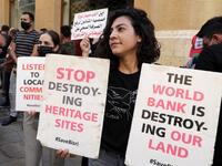 Demonstrators hold placards in front of the World Bank offices in the downtown district of the capital Beirut on July 25, 2020, as they protest against the Bisri dam project, partly financed by the World Bank. The government says the Bisri dam is vital to tackling chronic water shortages. But activists say it will ravage most of the region's farmland and historic sites, and they also fear the consequences of building it on a seismic fault line.  ANWAR AMRO / AFP