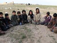Saddam, (R) a 15 year old Yazidi boy and ten other Yazidi children gather in a area held by the US-backed Kurdish-led Syrian Democratic Forces (SDF), in the eastern Syrian province of Deir Ezzor, after fleeing the Islamic State (IS) group's embattled holdout of Baghouz, on February 23, 2019. The eleven Yazidi children were rescued by US-backed forces from IS's last sliver of territory in the village of Baghouz near the Iraqi border. (AFP / -)