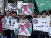 Palestinian demonstrators wave the green flag of the Hamas movement, carry pictures of Abu Dhabi's Crown Prince Sheikh Mohammed bin Zayed Al-Nahyan as well as banners with slogans against a US-brokered deal between Israel and the UAE to normalise relations, during a rally in the northern Gaza Strip refugee camp of Jabalia, on August 15, 2020. MAHMUD HAMS / AFP