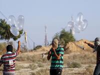 Palestinians prepare incendiary devices attached to inflated condoms to be directed and flown towards Israel, near Rafah along the border between the Gaza Strip and Israel on August 21, 2020. SAID KHATIB / AFP
