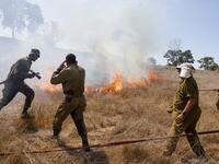 Israeli soldiers battle a blaze in a field close to the southern Israeli kibbutz of Nir Am near the border with the Gaza Strip on August 23, 2020, after it was reportedly set off by incendiary kites flown from the Palestinian enclave. menahem kahana / AFP