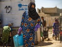 A displaced Syrian brings water back to their camp in a camp for the displaced in Syria's northeastern city of Hasakah on August 24, 2020. Delil SOULEIMAN / AFP