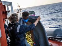 Civil sea rescue ship Sea-Watch 4 crew and Doctors without Borders members help migrants and cover them with blankets  (AFP)