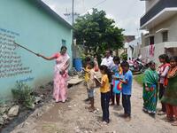 Half a dozen children in an Indian village gather around their teacher as she points a stick at a lesson painted on a wall, one of many which are part of an unusual effort to help poor students keep up with their education amid the coronavirus pandemic. AFP