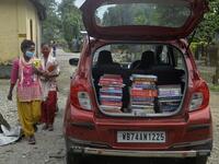 Youths from Merry view Tea Garden organisation walk near a book library car to attend a class as part of 'Tuition for Rs 10' project, origanized by Indian couple Anirban Nandy and Poulami Chaki Nandy for underprivileged students unable to assist online classes at Hatighisa village, some 26 km from Siliguri, on September 1, 2020, as schools remain closed due the Covid-19 coronavirus pandemic. DIPTENDU DUTTA / AFP