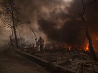 A man carrying belongings flees flames after a major fire broke out in the Moria migrants camp on the Greek Aegean island of Lesbos, on September 9, 2020.