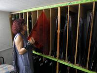 Lebanese stained glass artist Maya Husseini, 60, chooses red glass to be used on one of her works in progress, in her basement workshop on the outskirts of the capital Beirut, on September 18, 2020. ANWAR AMRO / AFP