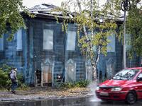 People walk past a traditional wooden house in the Siberian city of Tomsk on September 8, 2020. Tomsk is considered to be one of the oldest towns in Siberia founded in 1604. Wooden architecture is one of the symbols of the city of Tomsk, its distinctive feature. Today Tomsk is the only city in Siberia where the background wooden buildings have been preserved, reflecting the manor structure of the city streets. Unfortunately, many wooden houses are not in very good condition and require restoration. Alexande