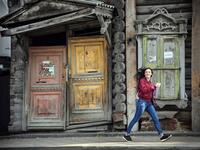 A woman walks past a traditional wooden house in the Siberian city of Tomsk on September 8, 2020. Tomsk is considered to be one of the oldest towns in Siberia founded in 1604. Wooden architecture is one of the symbols of the city of Tomsk, its distinctive feature. Today Tomsk is the only city in Siberia where the background wooden buildings have been preserved, reflecting the manor structure of the city streets. Unfortunately, many wooden houses are not in very good condition and require restoration. Alexan
