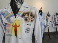 View of white coats used by doctors fighting against COVID-19 and decorated by Panamanian artists, in Panama City, on September 26, 2020. More than 20 doctor's coats fighting against COVID-19 that were disinfected and painted by Panamanian artists will be auctioned off from October 1 to 4. The funds will go to 20 health centers. Luis ACOSTA / AFP