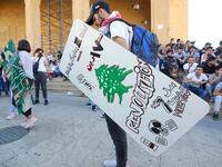 Lebanese demonstrators carrying shields attend a demonstration, marking the first anniversary of a non-sectarian protest movement, in the capital Beirut's downtown area on October 17, 2020. Anwar AMRO / AFP