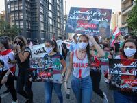 Lebanese protesters lift placards during a demonstration marking the one year anniversary of the beginning of a nationwide anti-government protest movement, in the capital Beirut on October 17, 2020. Hundreds marched in Lebanon's capital to mark the first anniversary of a non-sectarian protest movement that has rocked the political elite but has yet to achieve its goal of sweeping reform. ANWAR AMRO / AFP