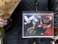 A woman holds a picture of Samuel Paty, Place de la Liberte in Lille on October 18, 2020, in homage to the history teacher, two days after he was beheaded by an attacker who was shot dead by policemen. FRANCOIS LO PRESTI / AFP