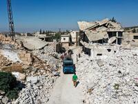 People collect scrap steel rods from the rubble and destruction in the aftermath of aerial bombardment in the town of Ihsim in Syria's rebel-held northwestern Idlib province, on October 18, 2020. Omar HAJ KADOUR / AFP