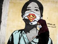 A Palestinian artist paints a mural of a mask-clad schoolgirl in Gaza City on October 22, 2020, amid the novel coronavirus pandemic crises. Mohammed ABED / AFP