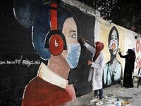 Palestinian students paint murals of mask-clad young girls in Gaza City on October 22, 2020, amid the novel coronavirus pandemic crises. Mohammed ABED / AFP