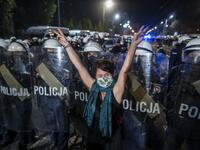 A protestor shows the V sign in front of a line of riot police guarding the house of Jaroslaw Kaczynski, leader of Poland's ruling Law and Justice party (PIS) during a demonstration against a decision by the Constitutional Court on abortion law restriction,in Warsaw on October 23, 2020. Wojtek RADWANSKI / AFP