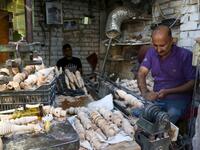 A carpenter shaves a piece of wood to make a narguileh (water pipe) at his workshop in Iraq's central holy city of Karbala on October 21, 2020. The business of strictly gender-separated cafes has carried on, despite the heavy health risks associated with smoking and a full-blown pandemic that has brought an average of 4,000 new coronavirus cases a day to Iraq. Mohammed SAWAF / AFP