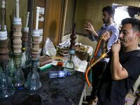 Employees prepare narguilehs (water pipes) for customers at a coffee shop in Iraq's central holy city of Karbala on October 21, 2020. The business of strictly gender-separated cafes has carried on, despite the heavy health risks associated with smoking and a full-blown pandemic that has brought an average of 4,000 new coronavirus cases a day to Iraq. Mohammed SAWAF / AFP
