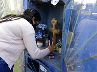 A woman lights a candle as she visits a relative's tomb at a cemetery in Asuncion on November 1, 2020, on All Saints' Day. Municipal cemeteries in Paraguay will be open to the public only on November 1 and 2, during All Saints' Day and the Day of the Dead, amid the new coronavirus pandemic. NORBERTO DUARTE / AFP