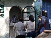 Women visit a relative's tomb at a cemetery in Asuncion on November 1, 2020, on All Saints' Day. Municipal cemeteries in Paraguay will be open to the public only on November 1 and 2, during All Saints' Day and the Day of the Dead, amid the new coronavirus pandemic. NORBERTO DUARTE / AFP
