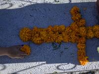 A woman decorates a relative's grave with Mexican marigolds forming a cross at La Magdalena Pantheon, in San Pedro Cholula, Puebla state, Mexico, on November 1, 2020, on All Saints' Day, amid the COVID-19 coronavirus pandemic. Local authorities have restricted the visit times and the number of visitors in cemeteries due to the pandemic. PEDRO PARDO / AFP