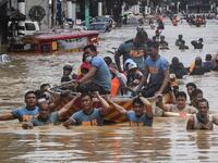 Rescuers pull a rubber boat carrying residents through a flooded street after Typhoon Vamco hit in Marikina City, suburban Manila on November 12, 2020. Ted ALJIBE / AFP