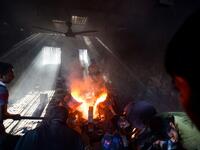 In this picture taken on November 12, 2020 dockyard workers pour molten iron in a mold to make a propeller at a workshop on the banks of the Buriganga river in Char Kaliganj on the outskirts of Dhaka. Rivers are the lifeblood of the delta nation of 168 million people where much of the low-lying land is accessed via boat, with Bangladesh's strong economic growth of recent years fuelling more investments in new and bigger ships. Munir UZ ZAMAN / AFP