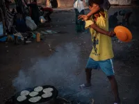 An Ethiopian boy, who fled the Ethiopia's Tigray conflict as a refugee, avoids smoke as he helps to cook at Um Raquba refugee camp in Gedaref, eastern Sudan, on December 1, 2020. Yasuyoshi CHIBA / AFP