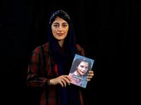 Employee Parisa Agha Mohammadi poses with a bestselling book of the Saless Publishing House in Iran's capital Tehran, on October 11, 2020. ATTA KENARE / AFP