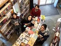 Employees pose for a picture at a bookstore of the Nashre-Cheshmeh Publishing House on Karim Khan street in the Iranian capital Tehran, on December 5, 2020. ATTA KENARE / AFP