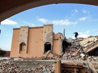 A youth climbs the rubble of a destroyed building in the city of Tawergha, some 200 kilometres (125 miles) east of Libya's capital close to the port city of Misrata, on December 12, 2020. When Libyan dictator Moamer Kadhafi was toppled, people took revenge on those they saw as his supporters -- including the entire town of Tawergha, whose 40,000 residents were forced to flee. Now, almost a decade later since militia forces rampaged through the town torching homes, destroying buildings and leaving farms in r